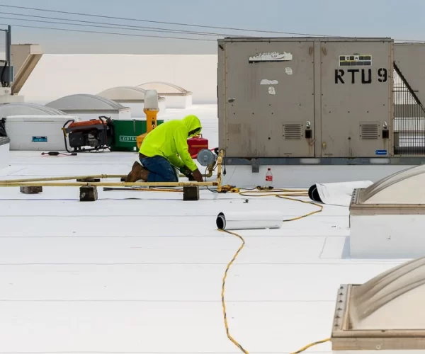 RoofConnect Roofer performing roof leak repairs on a commercial flat roof in Eastern U.S.